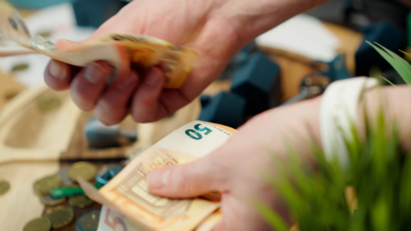 Mains comptant des billets et pièces en euros
